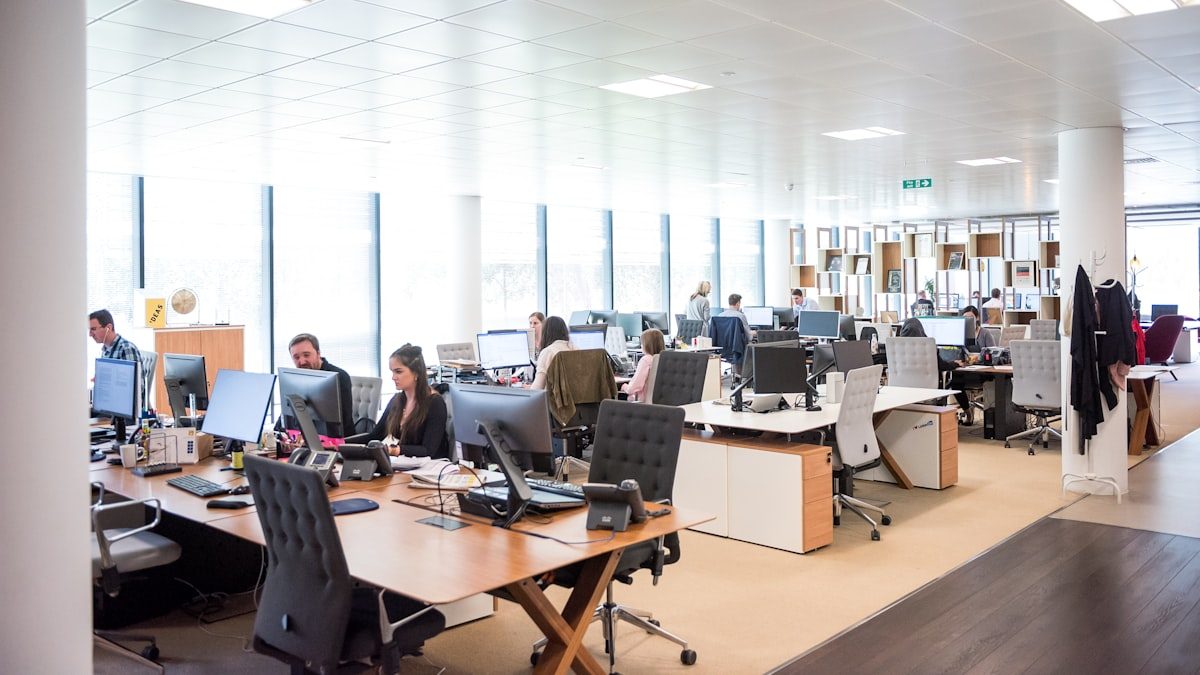 Open space de bureaux lumineux avec employés et téléphones fixes sur les postes