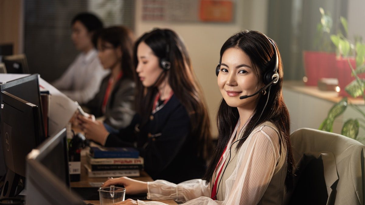 Conseillère de centre de contact au casque à son poste, collègues en arrière-plan